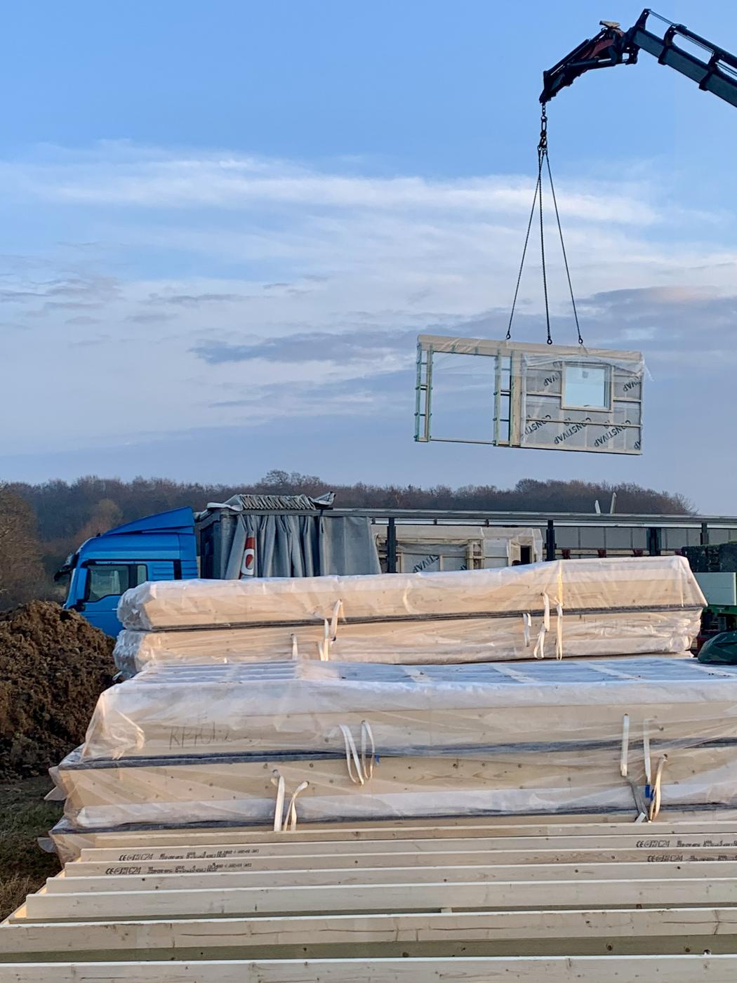 A wall panel lifted from the truck to the slab
